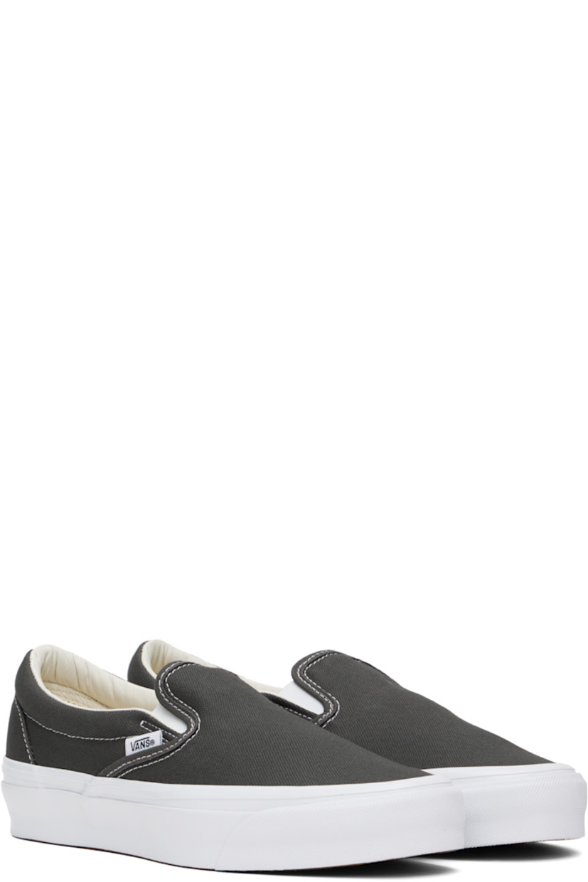 Low-top canvas slip-on sneakers in gray.

· Elasticized gussets at tongue
· Padded collar
· Logo flag at outer side
· Rubberized logo patch at heel
· Canvas lining
· Removable padded foam insole
· Treaded rubber sole
· Contrast stitching in white

Supplier color: Gunmetal