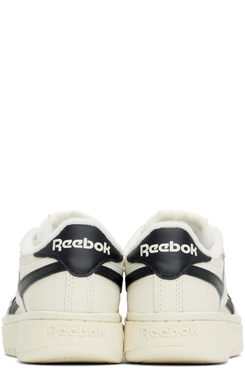 Low-top grained leather sneakers in off-white and black.

· Perforated detailing at toe
· Lace-up closure
· Logo patch at padded tongue
· Padded collar
· Inset logo patch at outer side
· Signature stripes at sides
· Logo printed at heel tab
· Logo embossed at heel
· Treaded rubber sole

Supplier color: Chalk/Core Blk/Chalk