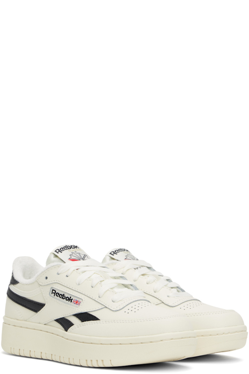 Low-top grained leather sneakers in off-white and black.

· Perforated detailing at toe
· Lace-up closure
· Logo patch at padded tongue
· Padded collar
· Inset logo patch at outer side
· Signature stripes at sides
· Logo printed at heel tab
· Logo embossed at heel
· Treaded rubber sole

Supplier color: Chalk/Core Blk/Chalk