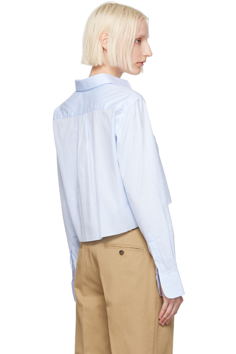 Cotton twill shirt.

· Spread collar
· Button closure
· Logo embroidered at front
· Raw edge at cropped hem
· Adjustable single-button barrel cuffs
· Box pleat at back yoke

Supplier color: Chambray blue
