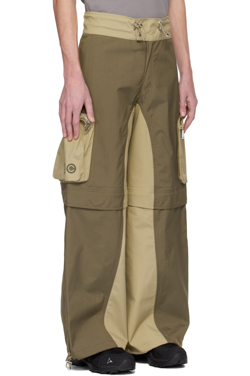 Loose-fit deadstock plain-woven stretch nylon cargo pants. Taped seams throughout.

· Water-resistant, breathable, and windproof
· Paneled construction
· Bungee-style drawstring at waistband and cuffs
· Four-pocket styling
· Zip fly
· Zip fastening at knees for shorts styling
· Zip bellows pocket at outseams
· Rubber logo patches at outseam

Part of the Charlie Constantinou x 66°North collaboration.

Supplier color: Earth