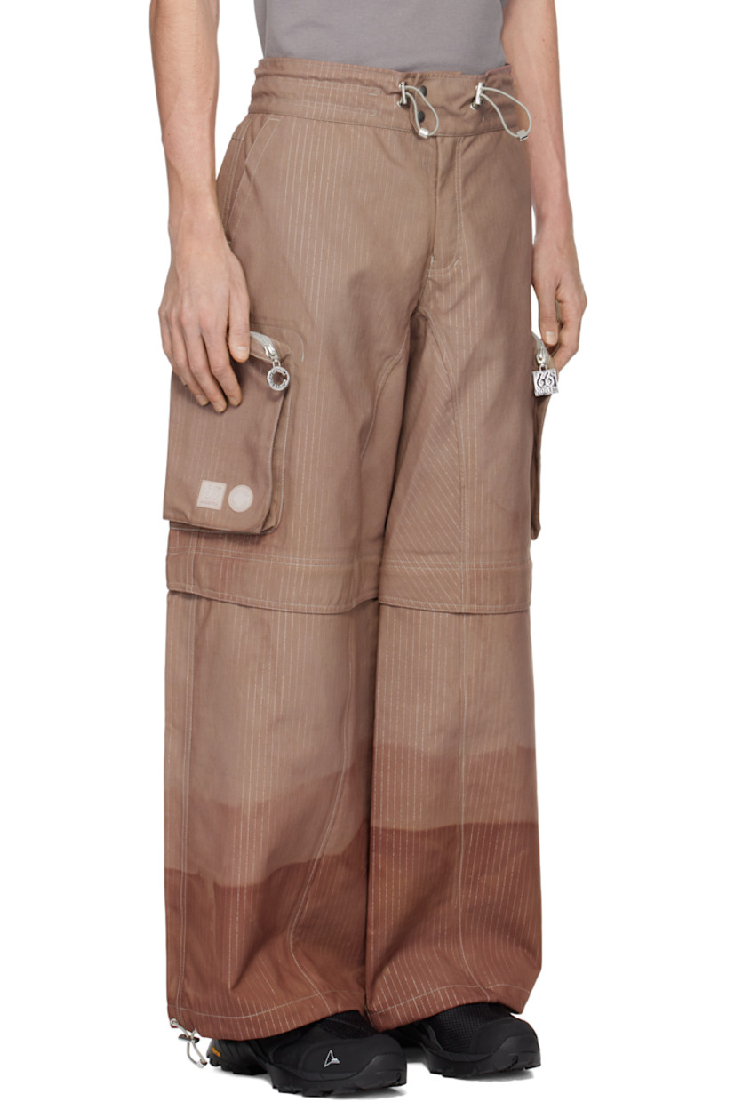 Hand-dyed deadstock plain-woven stretch nylon cargo pants. Reflective stripes and taped seams throughout.

· Bungee-style drawstring at waistband and cuffs
· Four-pocket styling
· Zip fly
· Zip fastening at knees for shorts styling
· Zip bellows pocket at outseams
· Rubber logo patches at outseam

Each item is unique. Please note coloration may vary.

Part of the Charlie Constantinou x 66°North collaboration.

Available exclusively at SSENSE.

Supplier color: C725