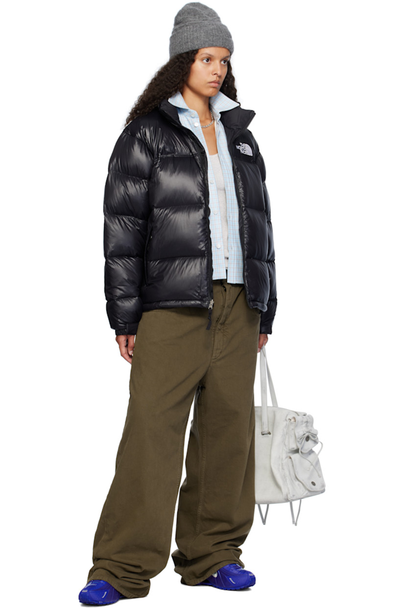 RDS-certified down-filled and quilted non-PFC DWR-coated recycled nylon ripstop jacket. Windproof, water-repellent, and abrasion-resistant.

· Packable
· Stowaway hood at funnel neck
· Concealed bungee-style drawstring at hood and hem
· Zip closure
· Logo embroidered at chest and back
· Zip pockets
· Packs into zip pocket
· Text embroidered at sleeve
· Velcro fastening at elasticized cuffs
· Triclimate® press-stud fastening at cuffs
· Zip pocket at interior
· Full nylon taffeta lining

Available exclusively at SSENSE.

Supplier color: TNF black shine

Fill: 85% down, 15% waterfowl feathers.