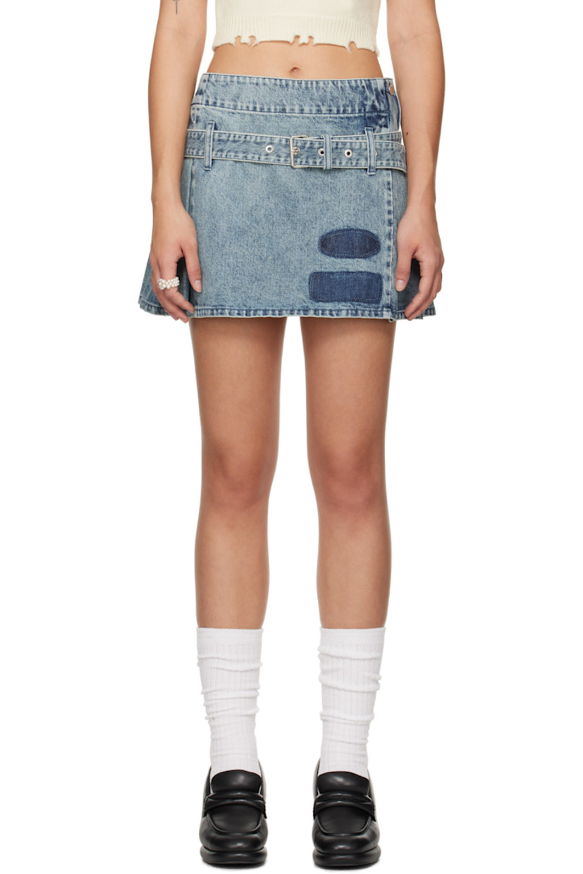 Non-stretch denim miniskirt. Fading throughout. 

· Asymmetrical construction
· Belt loops and detachable pin-buckle belt 
· Printed patches at front hem
· Knife pleats at side and back 
· Logo embroidered at back waistband

Supplier color: Blue