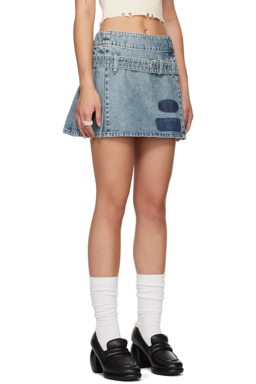 Non-stretch denim miniskirt. Fading throughout. 

· Asymmetrical construction
· Belt loops and detachable pin-buckle belt 
· Printed patches at front hem
· Knife pleats at side and back 
· Logo embroidered at back waistband

Supplier color: Blue