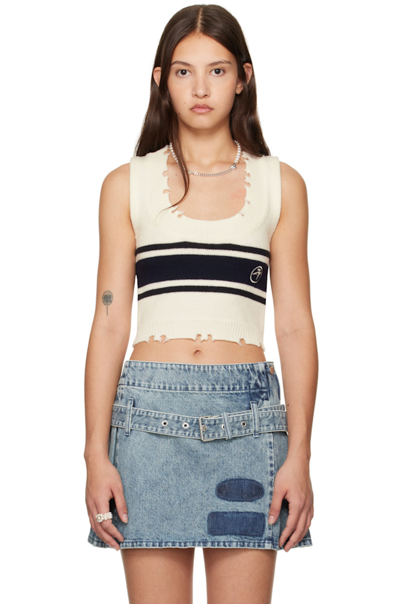 Knit virgin wool vest. 

· Distressing at rib-knit scoop neck and cropped hem
· Jacquard stripes at front and back
· Logo embroidered at front

Supplier color: Tofu