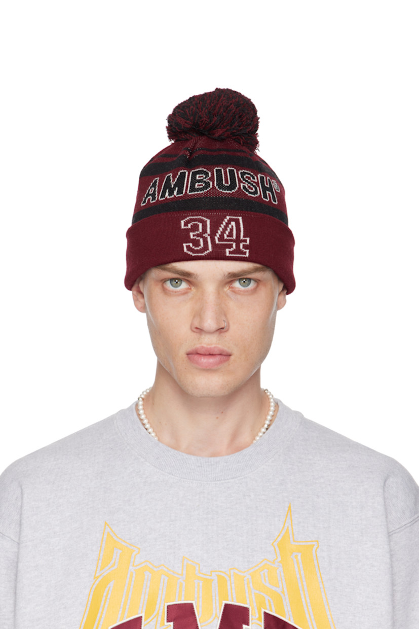 Knit virgin wool-blend beanie in red and black.

· Jacquard stripes throughout
· Pom-pom at crown
· Jacquard logo at face
· Jacquard text at rolled brim

Supplier color: Red