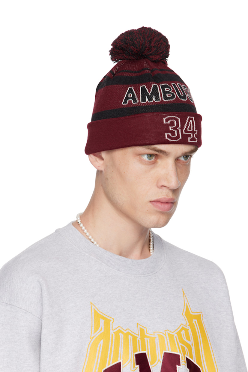 Knit virgin wool-blend beanie in red and black.

· Jacquard stripes throughout
· Pom-pom at crown
· Jacquard logo at face
· Jacquard text at rolled brim

Supplier color: Red