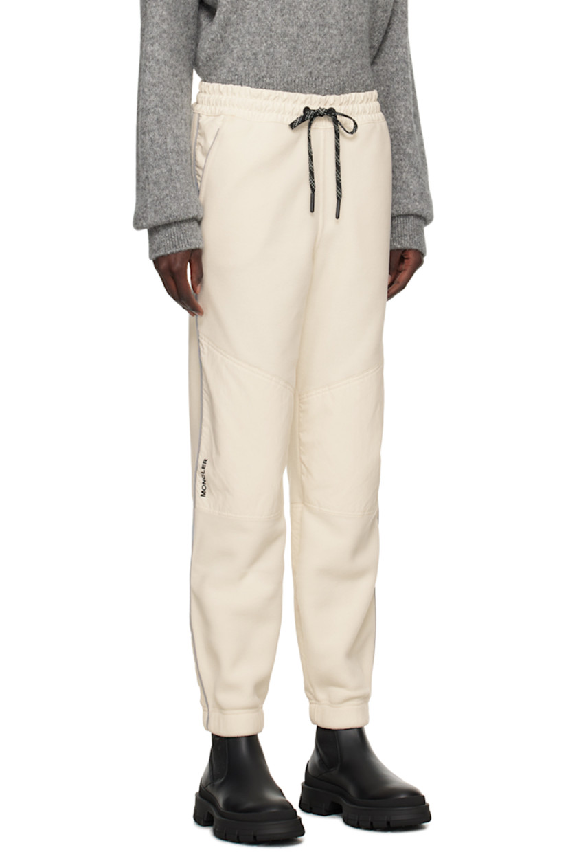 Polyester fleece lounge pants.

· Drawstring at elasticized waistband
· Two-pocket styling
· Logo patch at front pocket
· Taffeta panels at knees 
· Rubberized logo patch at knee
· Reflective stripe at outseams
· Locker loop at back waistband

Supplier color: 21L