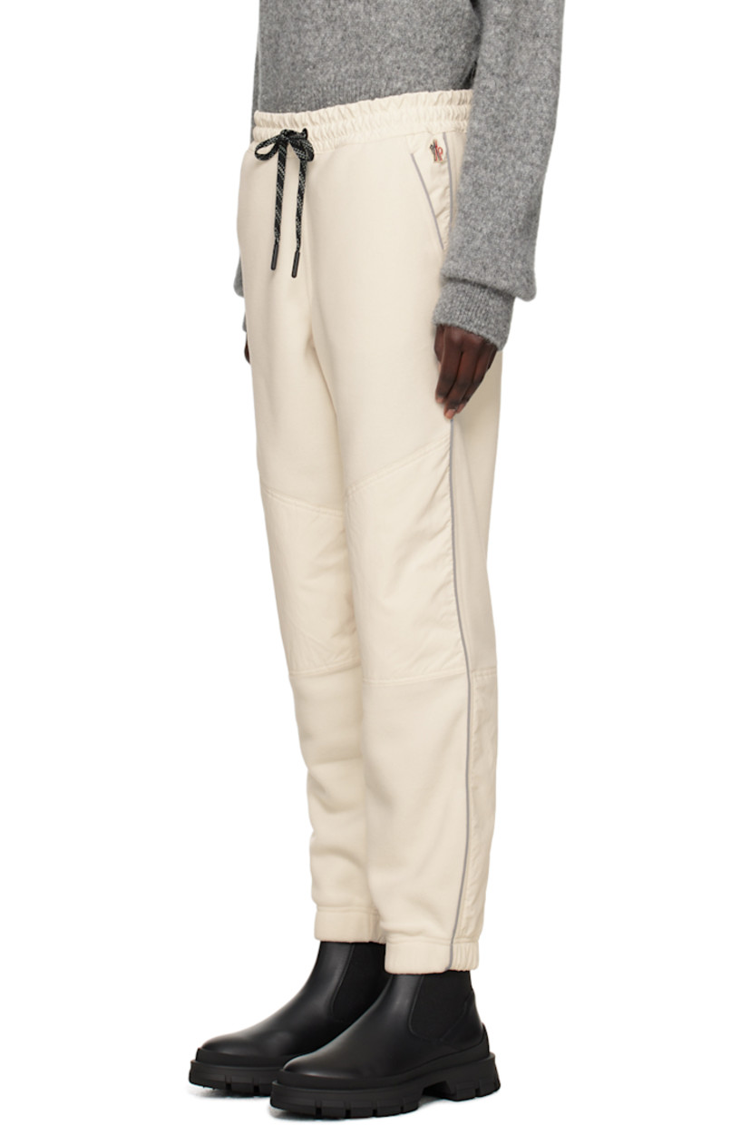Polyester fleece lounge pants.

· Drawstring at elasticized waistband
· Two-pocket styling
· Logo patch at front pocket
· Taffeta panels at knees 
· Rubberized logo patch at knee
· Reflective stripe at outseams
· Locker loop at back waistband

Supplier color: 21L