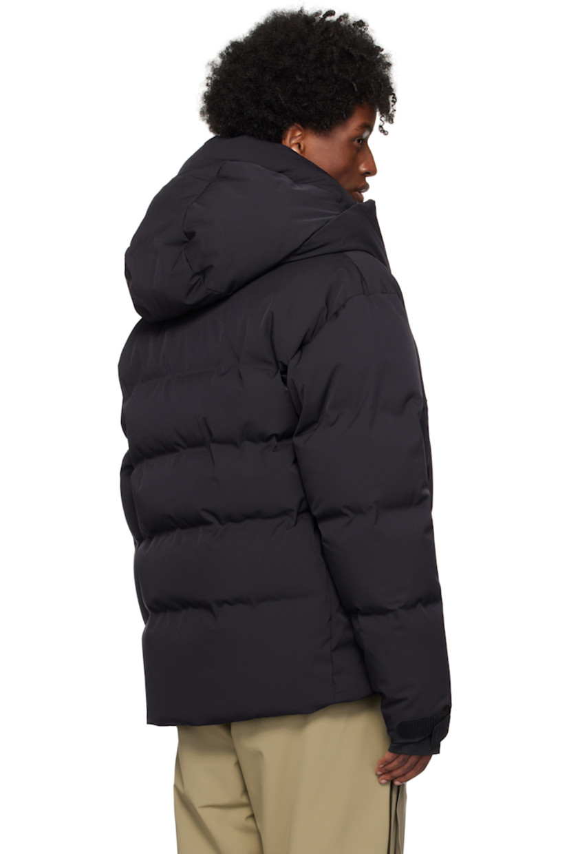 Down-filled and quilted 2L stretch nylon twill jacket. Water-repellent, windproof, lightweight, and breathable.

· Bungee-style drawstring at hood
· Stand collar
· Two-way zip closure
· Zip pockets
· Concealed bungee-style drawstring at hem
· Embroidered logo patch at sleeve
· Velcro strap at cuffs
· Thumbhole at inset jersey cuffs
· Zip pocket and powder skirt at interior
· Nylon satin lining
· YKK® Aquaguard® hardware

Supplier color: Navy blue

Fill: 90% goose down, 10% feathers.