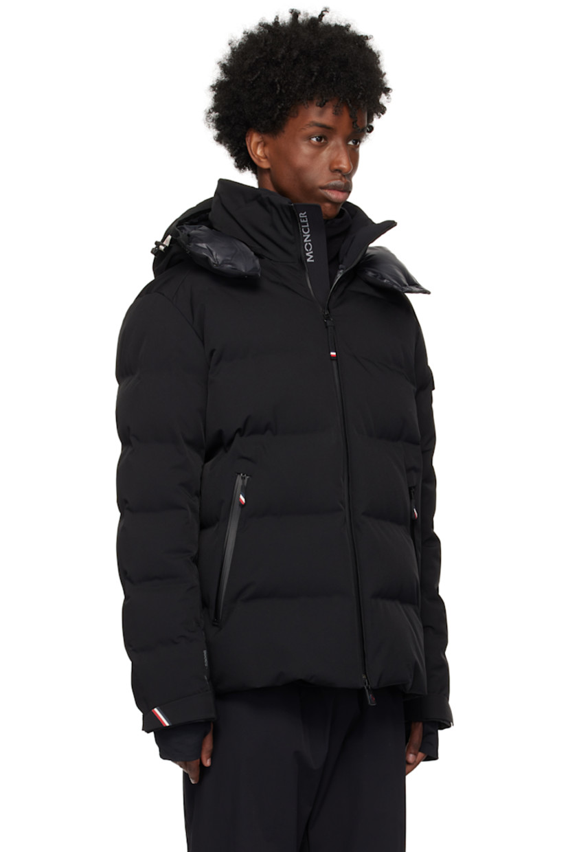 Down-filled and quilted 2L stretch nylon twill jacket. Water-repellent, windproof, lightweight, and breathable.

· Detachable hood
· Bungee-style drawstring and press-stud fastening at hood
· Stand collar
· Two-way zip closure
· Zip pockets
· Bungee-style drawstring at hem
· Embroidered logo patch and flap pocket at sleeve
· Velcro strap at cuffs
· Thumbhole at inset jersey cuffs
· Zip pocket and powder skirt at interior
· Nylon satin lining
· YKK® Aquaguard® hardware

Supplier color: Black

Fill: 90% goose down, 10% feathers.