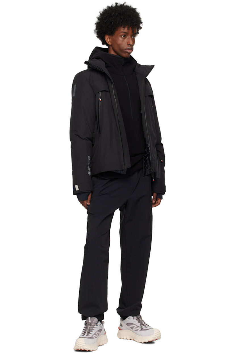 Paneled DIST-certified down-filled polyester twill jacket. 

· Windproof, waterproof, lightweight, and breathable
· RECCO® rescue technology
· Detachable hood
· Logo bonded at funnel neck
· Two-way zip closure
· Zip pockets
· Zip vent at underarm
· Rubberized logo patch at sleeve
· Velcro tab at cuffs
· Thumbhole at inset jersey cuffs
· Zip pocket and powder skirt at interior
· Nylon satin lining

Supplier color: Black

Fill: 90% pure goose down, 10% feather.