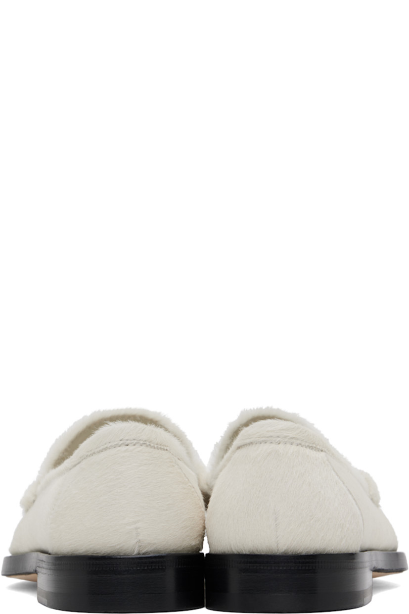 Calf hair loafers in off-white. 

· Moc toe 
· Strap with cutout at vamp
· Logo patch at padded footbed
· Buffed leather lining
· Stacked leather midsole 
· Calfskin sole with rubber injection 

Supplier color: Ivory