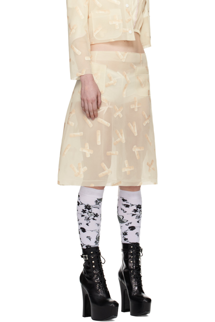 Semi-sheer double-faced polyethylene mesh midi skirt. Graphic pattern printed throughout. 

· Raw edge at waistband and hem
· Darts at front and back
· Patch pockets at front 
· Concealed zip closure at side seam 

Supplier color: Ecru