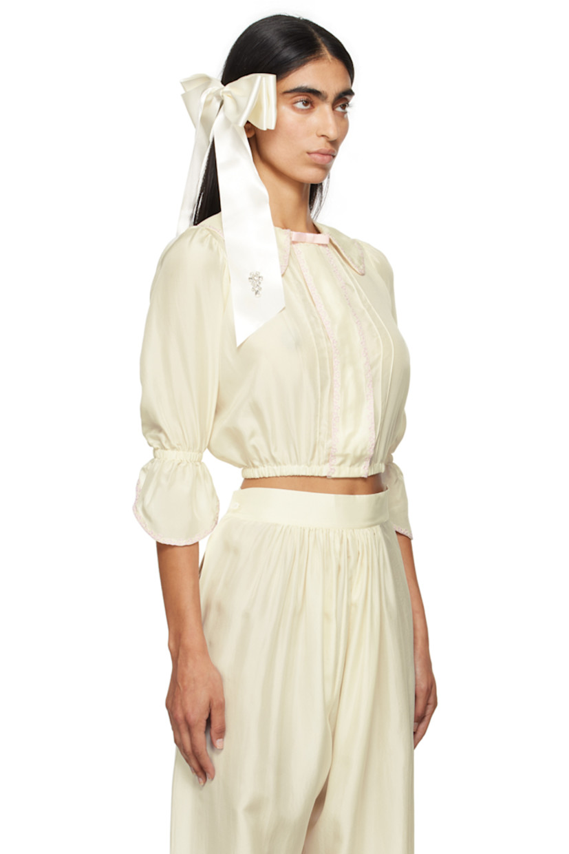 Silk satin blouse. Embroidered detailing throughout.

· Grosgrain bow at spread collar
· Concealed press-stud closure
· Pinched seams at front 
· Elasticized hem and flared cuffs
· Balloon sleeves 

Supplier color: Ecru