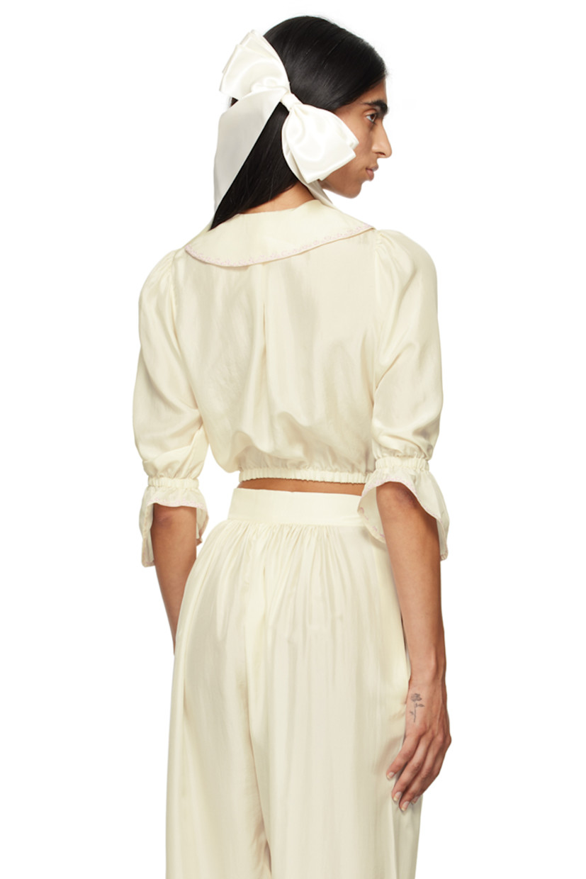 Silk satin blouse. Embroidered detailing throughout.

· Grosgrain bow at spread collar
· Concealed press-stud closure
· Pinched seams at front 
· Elasticized hem and flared cuffs
· Balloon sleeves 

Supplier color: Ecru