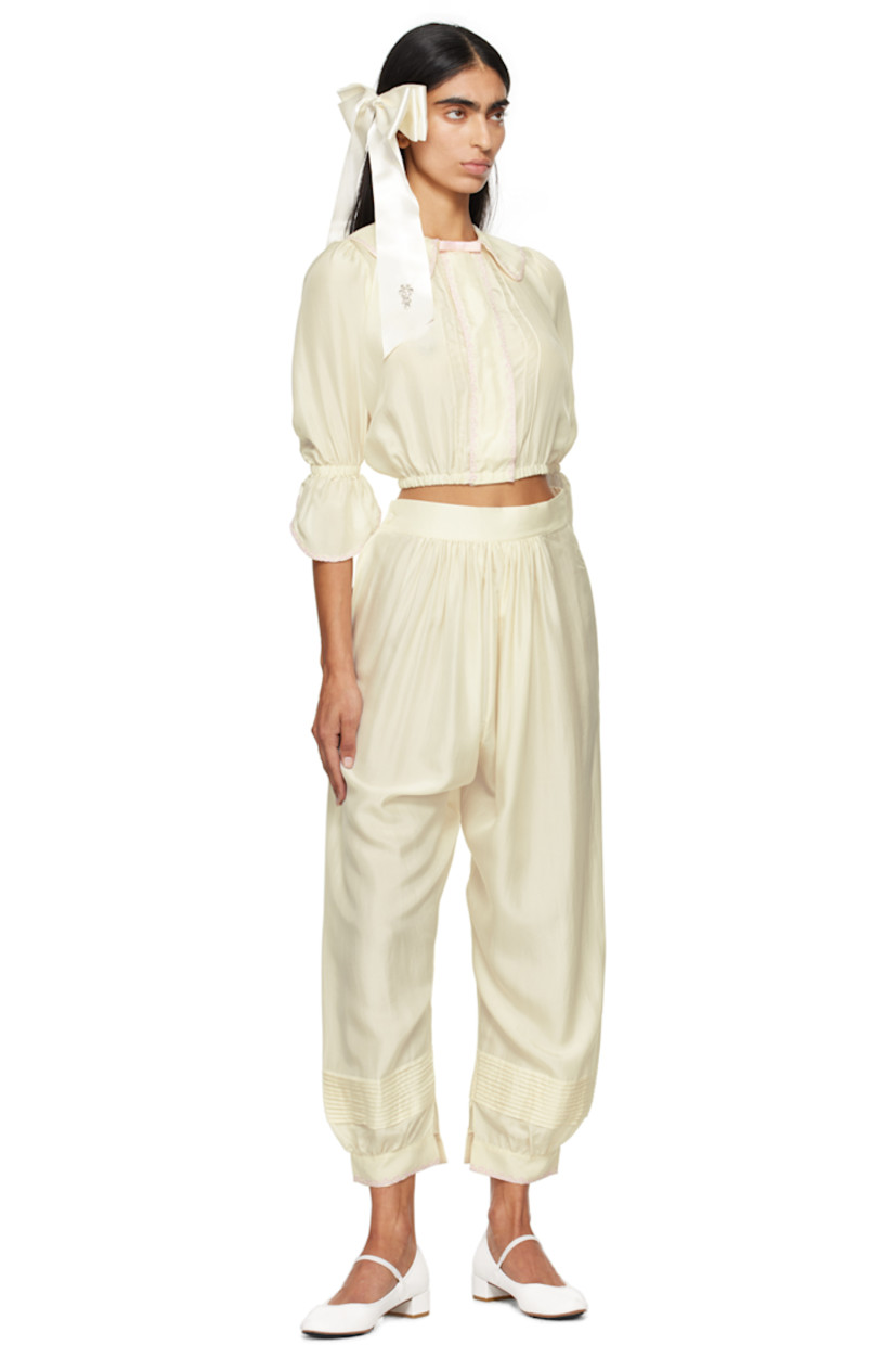 Silk satin blouse. Embroidered detailing throughout.

· Grosgrain bow at spread collar
· Concealed press-stud closure
· Pinched seams at front 
· Elasticized hem and flared cuffs
· Balloon sleeves 

Supplier color: Ecru