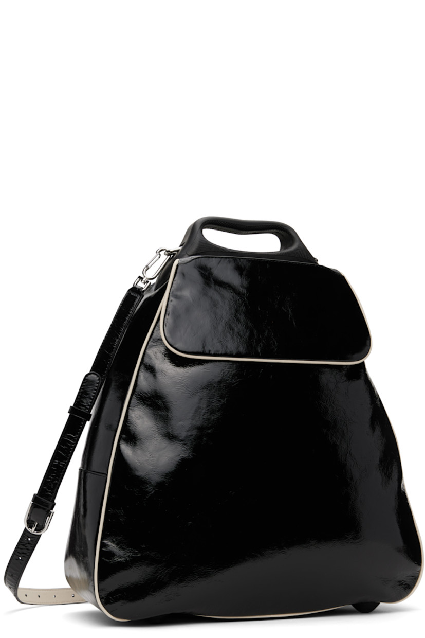 Patent grained leather top handle bag in black. 

· Piping throughout 
· Rigid leather carry handle
· Adjustable and detachable crossbody strap
· Flap with patch pocket at face 
· Rubberized bumper studs at base 
· Two-way zip closure 
· Patch pocket at interior 
· Twill lining
· H15.25" x W15" x D6.25"
· Total height: H17.25"

Part of the ECCO.kollektive x Kiko Kostadinov collaboration.

Supplier color: Black/Whitecap gray
