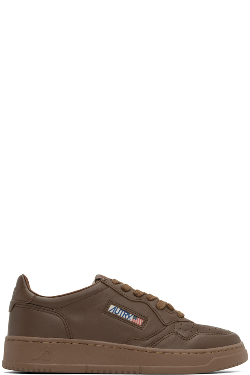 Low-top paneled grained goatskin sneakers in brown.

· Perforated detailing at toe
· Lace-up closure
· Logo patch at padded tongue
· Padded collar
· Inset logo patch at outer side
· Logo embossed at heel tab
· Pigskin suede, leather, and terrycloth lining
· Logo-embossed textured rubber midsole
· Treaded rubber sole

Supplier color: Patridge