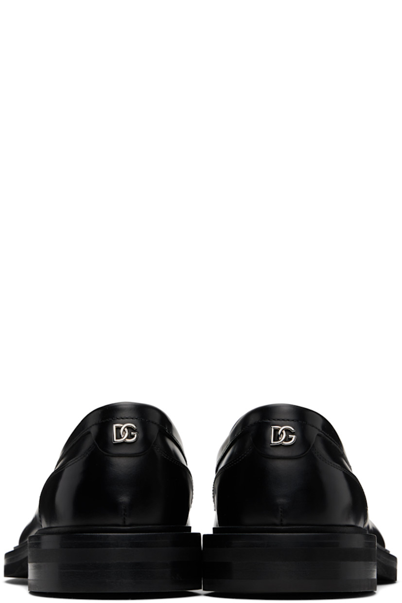 Brushed calfskin loafers in black.

· Moc toe
· Strap with cutout at vamp
· Silver-tone logo hardware at heel counter
· Buffed calfskin and suede lining
· Stacked leather heel with rubber injection 
· Treaded rubber sole

Supplier color: Nero