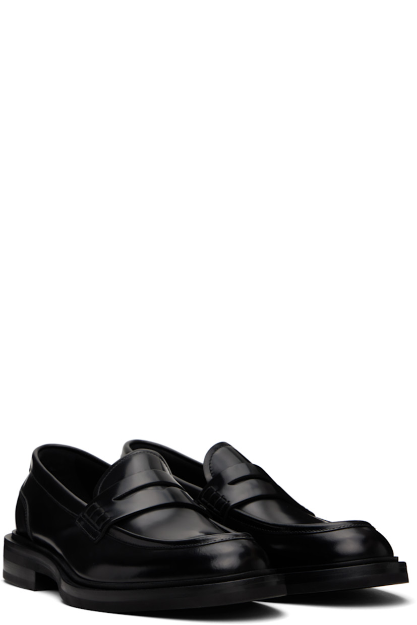 Brushed calfskin loafers in black.

· Moc toe
· Strap with cutout at vamp
· Silver-tone logo hardware at heel counter
· Buffed calfskin and suede lining
· Stacked leather heel with rubber injection 
· Treaded rubber sole

Supplier color: Nero