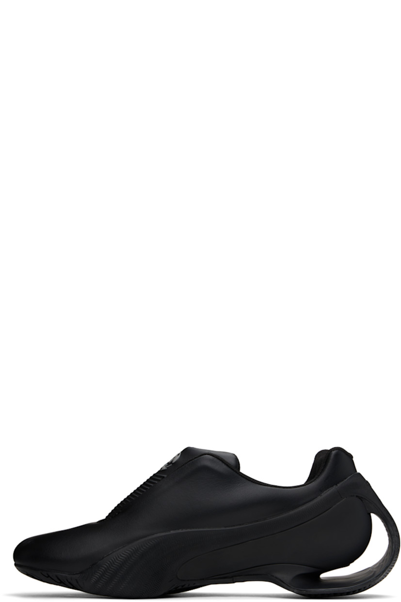Low-top buffed faux-leather slip-on sneakers in black.  

· Logo bonded at toe
· Logo embossed at padded tongue
· Concealed velcro fastenings and elasticized gussets at tongue
· Padded collar
· Textured formstrip at sides
· Logo embossed at heel counter
· Mesh lining
· Sculptural heel with cutout
· Treaded rubber sole

Part of the Puma x Rombaut collaboration. 

Supplier color: Black