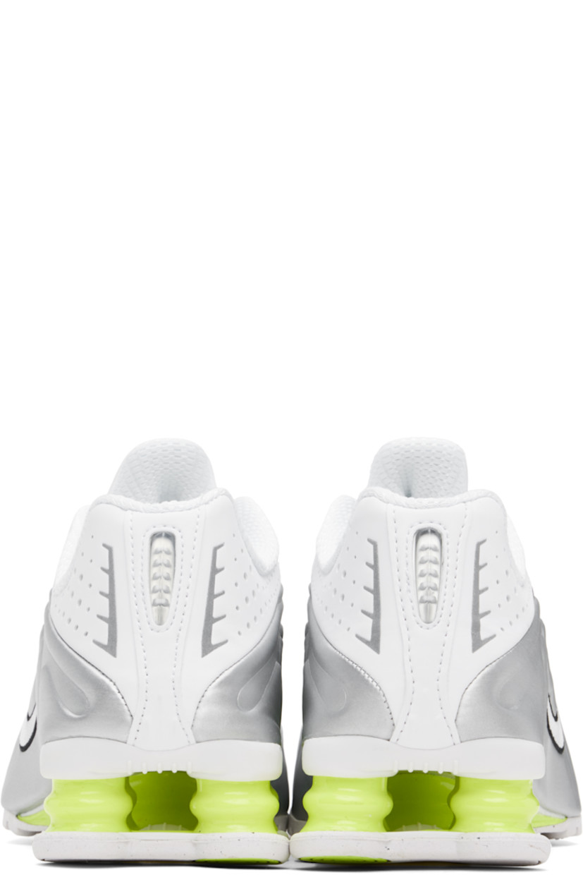 Low-top textured faux-leather and mesh sneakers in white and silver tone.

· Perforations and reflective trim throughout
· Lace-up closure
· Logo bonded at padded tongue
· Logo appliqué at tongue
· Padded collar
· Swoosh embroidered at sides
· Mesh lining
· Nike Shox units at midsole
· Treaded rubber sole

Please note that this item may be shipped only within North America.

Supplier color: White/Metallic silver/Volt/White