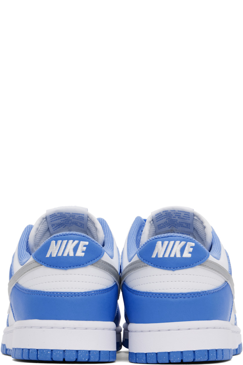 Low-top buffed leather and faux-leather sneakers in white and blue.

· Perforations at toe
· Lace-up closure
· Logo patch at padded tongue
· Padded collar
· Swoosh appliqué at sides
· Logo embroidered at heel tab
· Mesh lining
· Treaded rubber sole

Please note that this item may be shipped only within North America.

Supplier color: Royal pulse/Metallic