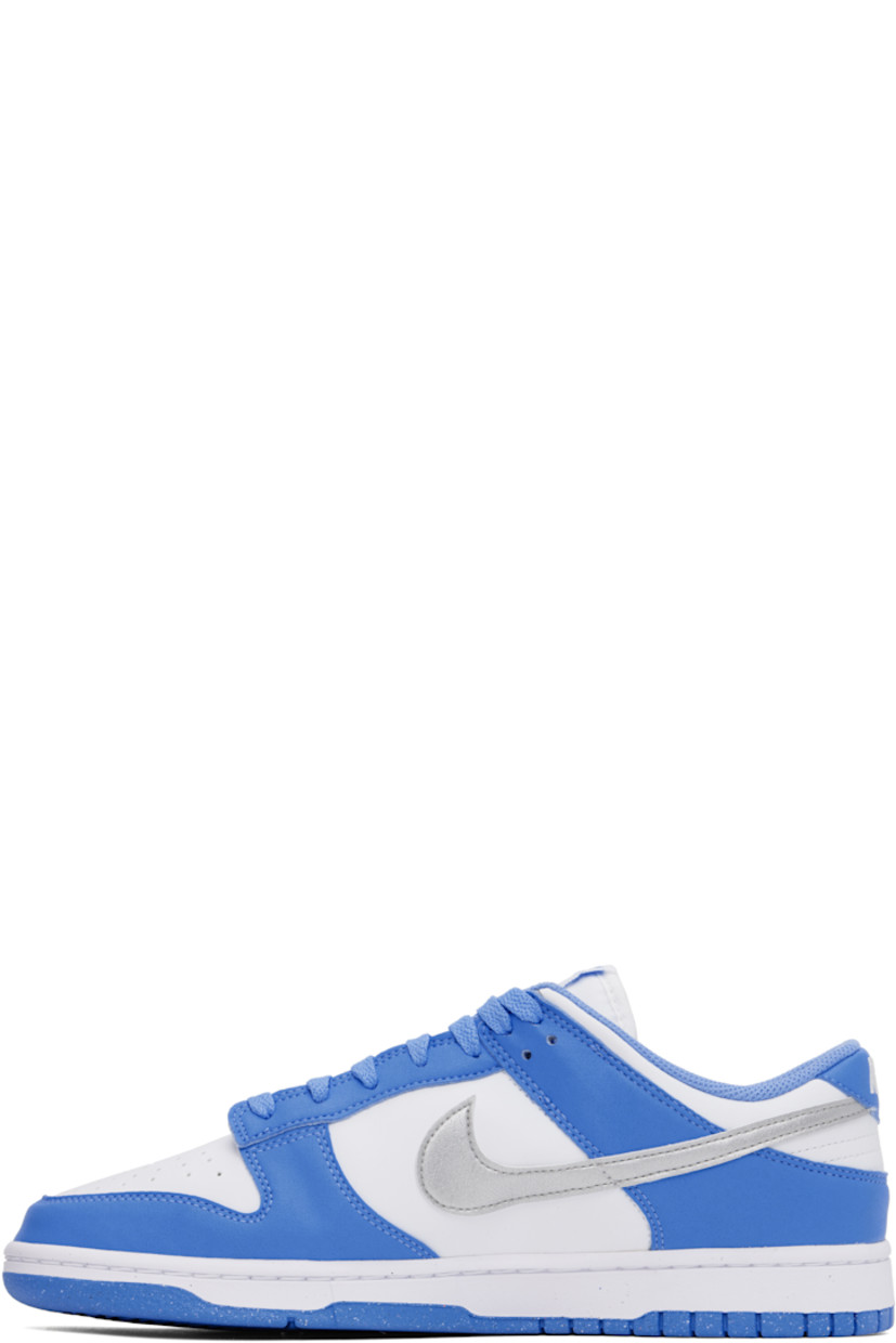Low-top buffed leather and faux-leather sneakers in white and blue.

· Perforations at toe
· Lace-up closure
· Logo patch at padded tongue
· Padded collar
· Swoosh appliqué at sides
· Logo embroidered at heel tab
· Mesh lining
· Treaded rubber sole

Please note that this item may be shipped only within North America.

Supplier color: Royal pulse/Metallic