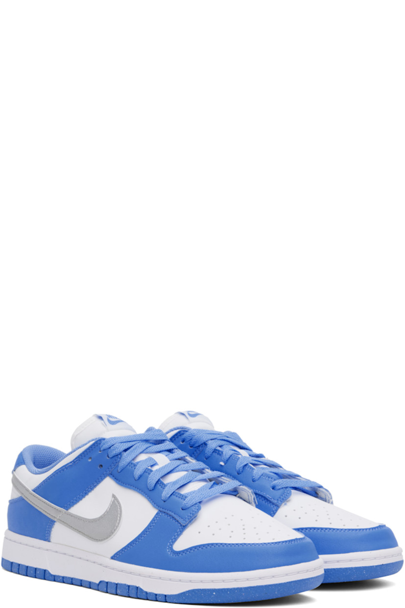 Low-top buffed leather and faux-leather sneakers in white and blue.

· Perforations at toe
· Lace-up closure
· Logo patch at padded tongue
· Padded collar
· Swoosh appliqué at sides
· Logo embroidered at heel tab
· Mesh lining
· Treaded rubber sole

Please note that this item may be shipped only within North America.

Supplier color: Royal pulse/Metallic