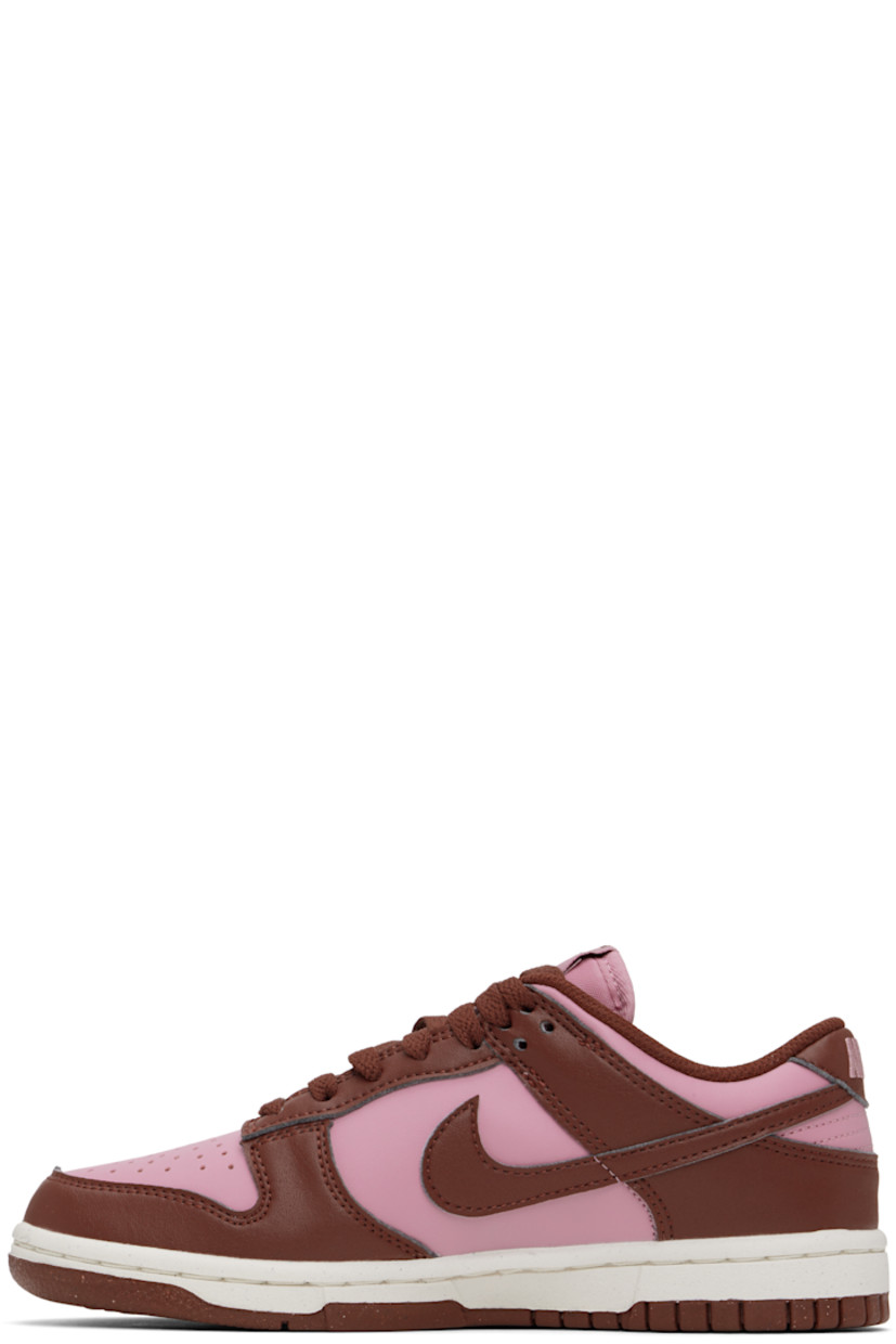 Low-top buffed leather sneakers in pink and brown.

· Perforated detailing at toe
· Lace-up closure
· Logo patch at padded tongue
· Padded collar
· Swoosh appliqué at sides
· Logo embroidered at heel tab
· Mesh lining
· Textured foam rubber midsole
· Treaded rubber sole

Please note that this item may be shipped only within North America.

Supplier color: White/Elemental pink/Dark pony