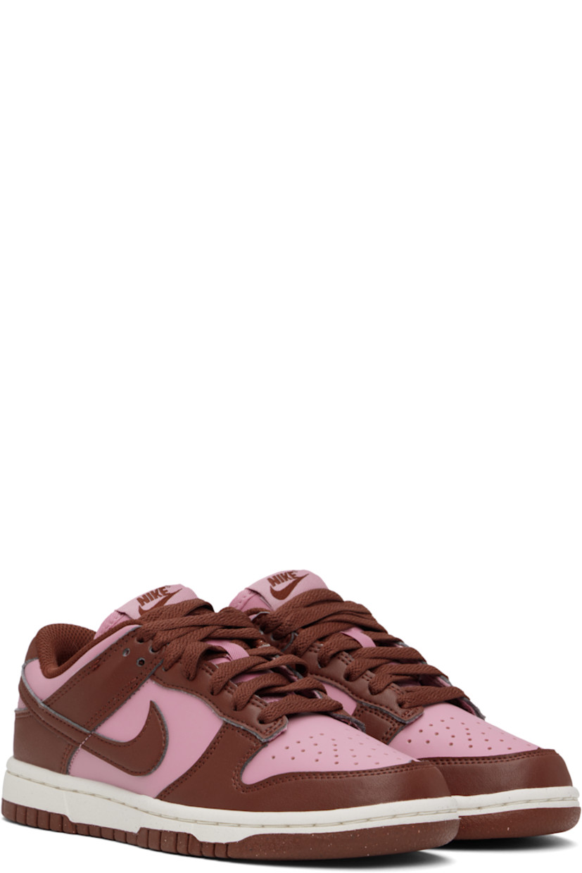 Low-top buffed leather sneakers in pink and brown.

· Perforated detailing at toe
· Lace-up closure
· Logo patch at padded tongue
· Padded collar
· Swoosh appliqué at sides
· Logo embroidered at heel tab
· Mesh lining
· Textured foam rubber midsole
· Treaded rubber sole

Please note that this item may be shipped only within North America.

Supplier color: White/Elemental pink/Dark pony