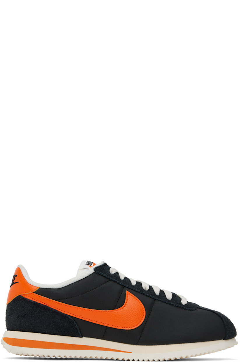Low-top canvas, suede, and grained faux-leather sneakers in black and orange.

· Lace-up closure
· Logo patch at padded tongue
· Padded collar
· Swoosh appliqué at sides
· Logo embroidered at heel tab
· Mesh lining
· Foam rubber midsole
· Treaded rubber sole

Please note that this item may be shipped only within North America.

Supplier color: Black/Sail/Muslin/Safety orange