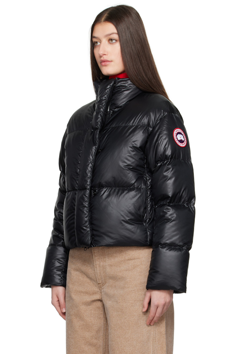Down-filled and quilted recycled nylon ripstop jacket. Packable, lightweight, water-repellent, and wind-resistant.

· Stand collar
· Two-way zip closure with button placket
· Seam pockets
· Bungee-style drawstring at cropped hem
· Dropped shoulders
· Embroidered logo patch at sleeve
· Inset rib-knit cuffs
· Detachable logo-woven shoulder straps at interior
· Welt and zip pocket at interior
· Mesh patch pockets at interior
· Full satin lining

Supplier color: Black

 Fill: 90% duck down, 10% down feather.