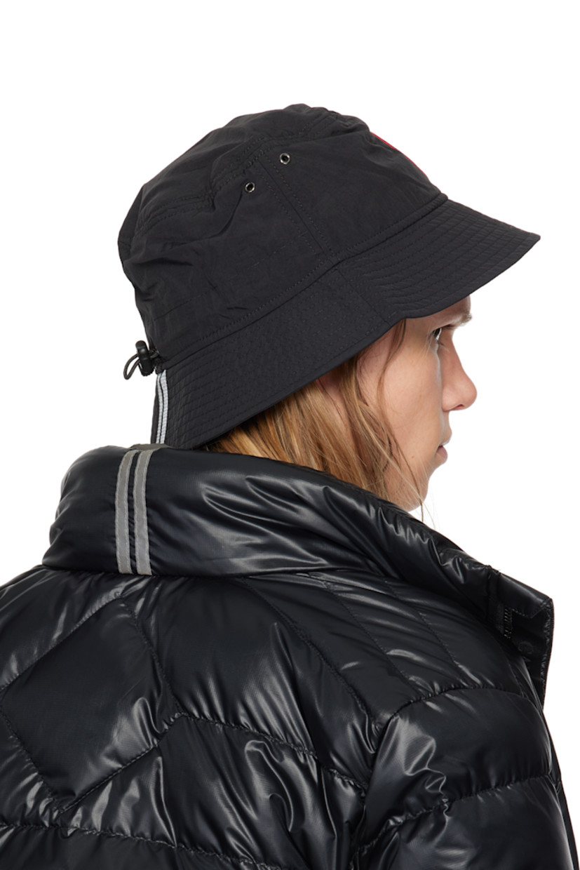 Nylon taffeta bucket hat in black.

· Lightweight, water-repellent, windproof, and breathable
· Metal eyelets at crown
· Embroidered logo patch at face
· Reflective trim at quilted brim
· Bungee-style drawstring at back face
· Mesh lining

Supplier color: Black