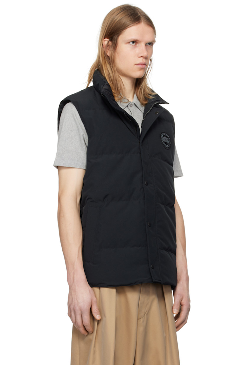 Down-filled quilted Arctic Tech® polyester- and cotton-blend duck canvas vest. Water-repellent.

· Stand collar
· Two-way zip closure with press-stud placket
· Embroidered logo patch at chest
· Welt pockets
· Droptail hem
· Zip pocket at interior
· Full satin lining

Part of the Black Label collection.

Supplier color: Black

Fill: 80% duck down, 20% duck feather.