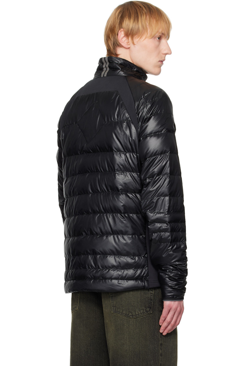 Packable down-filled and quilted stretch recycled nylon ripstop jacket. Stretch fleece panels throughout.

· Packs into waist pocket
· Lightweight, water-repellent, and wind-resistant
· Stand collar
· Two-way zip closure
· Zip pockets
· Raglan sleeves
· Embroidered logo patch at sleeve
· Elasticized cuffs
· Reflective trim at back collar
· Patch pockets at interior
· Full nylon satin lining

Supplier color: Black

Fill: 90% goose down, 10% goose feather.
