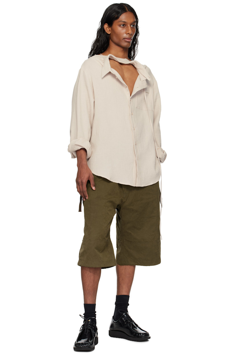 Cotton muslin shirt. 

· Raw edge at boat neck 
· Extended trim at spread collar 
· Button closure
· Logo embroidered at patch pocket
· Shirttail hem
· Dropped shoulders
· Buttoned barrel cuffs
· Twin pleats at back yoke

Supplier color: Stone