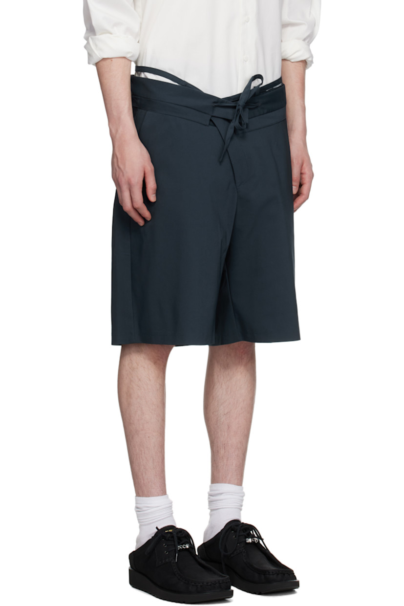 Plain-woven stretch cotton-blend shorts.

· Belt-style strap and raw edges at layered waistband
· Drawstring at foldover waistband
· Three-pocket styling
· Offset zip fly

Supplier color: Dark blue