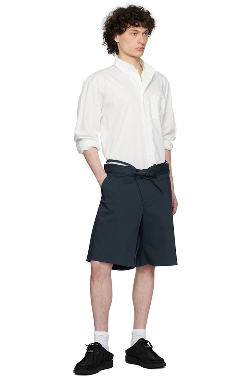 Plain-woven stretch cotton-blend shorts.

· Belt-style strap and raw edges at layered waistband
· Drawstring at foldover waistband
· Three-pocket styling
· Offset zip fly

Supplier color: Dark blue