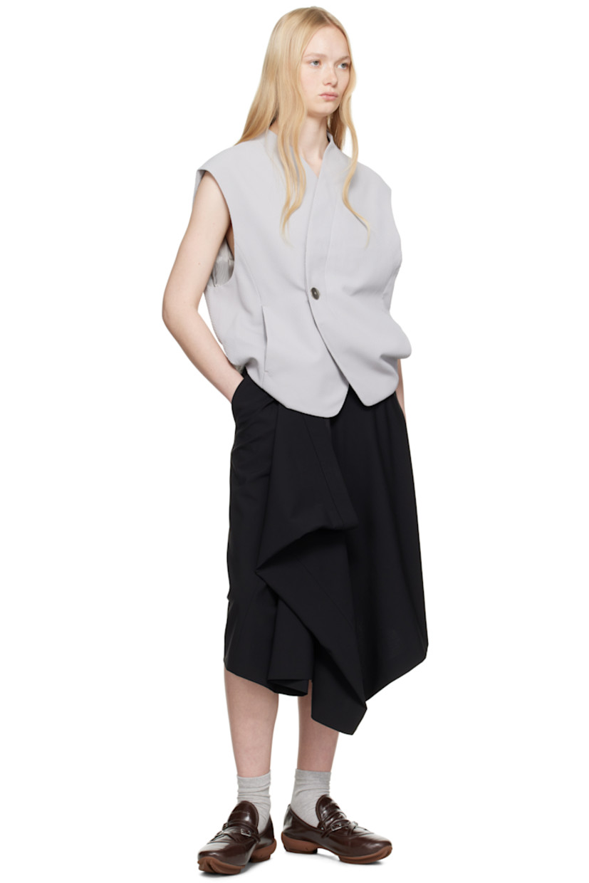Polyester dobby cloth vest.

· V-neck
· Offset button closure
· Darts at collar
· Seam pockets
· Frayed flag with topstitching at back
· Tucks and draping at back
· Exposed lining at back hem
· Welt pocket at interior
· Full logo-woven satin lining

Supplier color: Grey