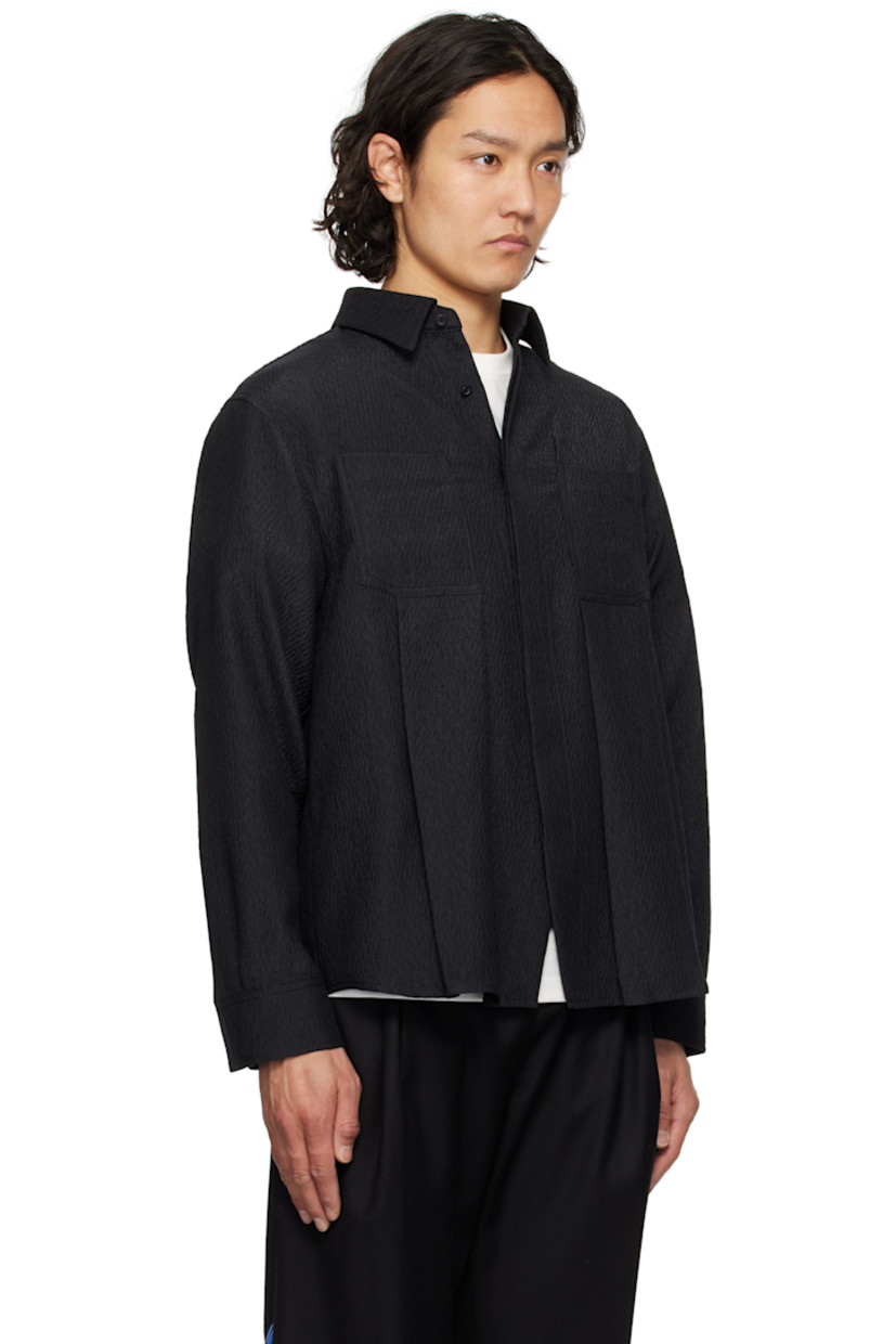 Oversized and crinkled plain-woven polyester shirt.

· Spread collar
· Button closure
· Box pleat at patch pockets
· Concealed double-button barrel cuffs
· Twin pleats with topstitching at back yoke
· Frayed appliqué at back hem

Supplier color: Noir