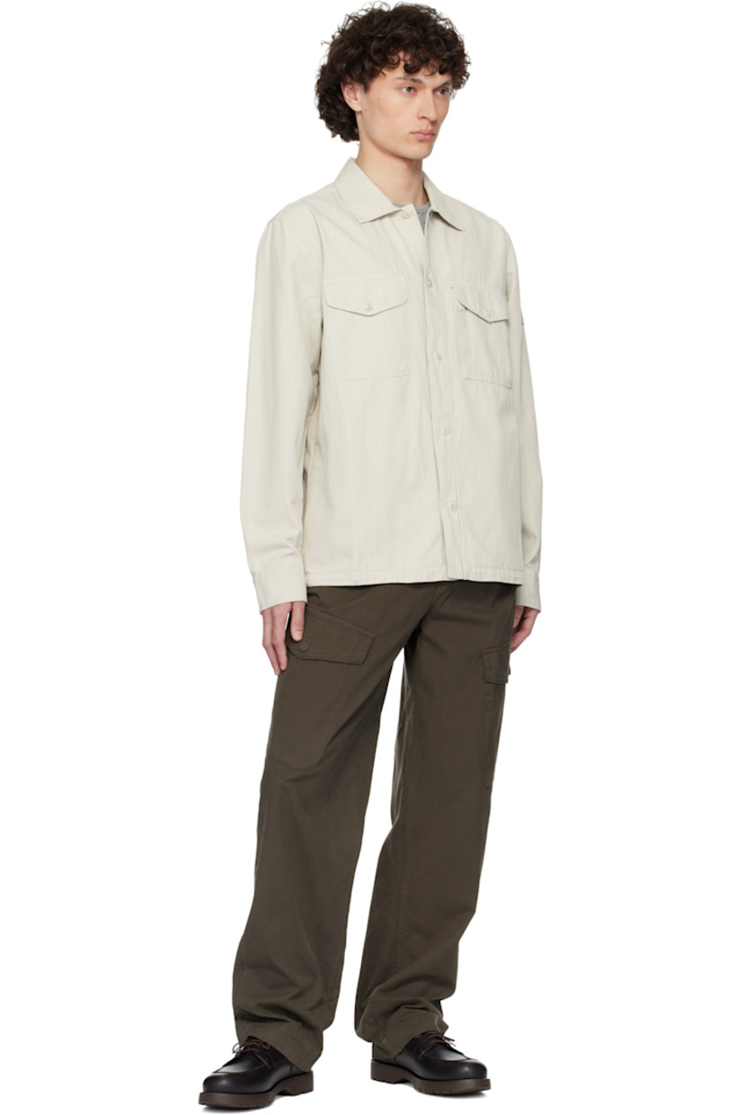 Cotton- and linen-blend herringbone shirt.

· Better Cotton™-certified and garment-dyed 
· Spread collar
· Button closure
· Flap pockets at chest
· Seam pockets
· Logo patch at sleeve
· Pleats at buttoned barrel cuffs

Supplier color: Stone beige