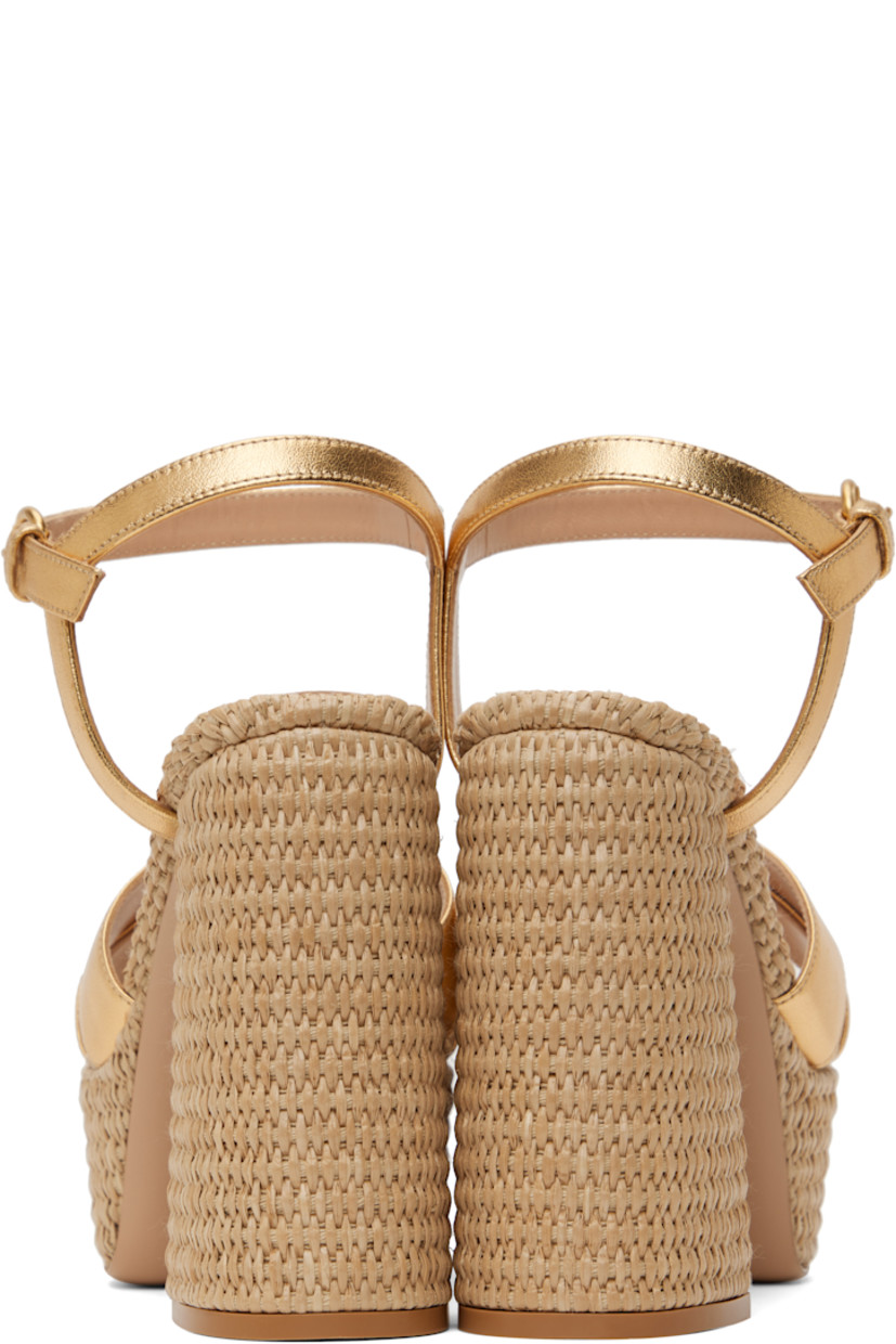 Handcrafted nappa leather heeled sandals in metallic gold tone.

· Open toe
· Crisscrossing straps at vamp
· Pin-buckle ankle strap
· Logo stamp at padded footbed
· Buffed leather lining
· Woven raffia heel and platform midsole
· Block heel with rubber injection
· Leather sole
· Platform: H2"
· Heel: H4.75"

Supplier color: Gold