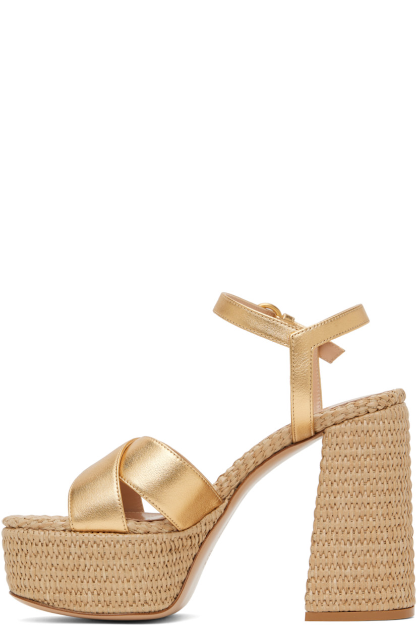 Handcrafted nappa leather heeled sandals in metallic gold tone.

· Open toe
· Crisscrossing straps at vamp
· Pin-buckle ankle strap
· Logo stamp at padded footbed
· Buffed leather lining
· Woven raffia heel and platform midsole
· Block heel with rubber injection
· Leather sole
· Platform: H2"
· Heel: H4.75"

Supplier color: Gold