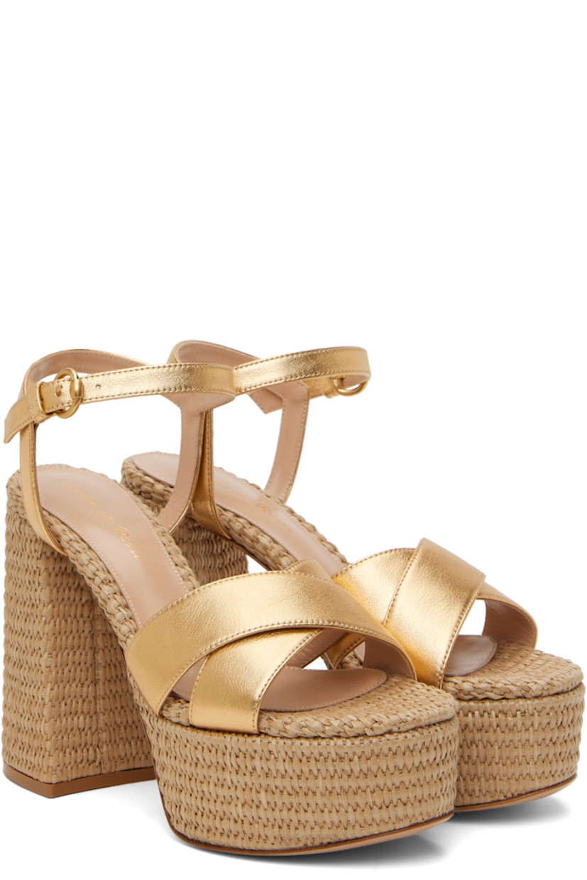 Handcrafted nappa leather heeled sandals in metallic gold tone.

· Open toe
· Crisscrossing straps at vamp
· Pin-buckle ankle strap
· Logo stamp at padded footbed
· Buffed leather lining
· Woven raffia heel and platform midsole
· Block heel with rubber injection
· Leather sole
· Platform: H2"
· Heel: H4.75"

Supplier color: Gold