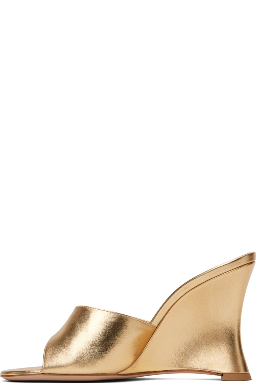 Nappa calfskin heeled sandals in metallic gold tone.

· Open toe
· Logo hardware at vamp
· Logo stamp at padded leather footbed
· Grained leather lining
· Covered wedge heel with rubber injection
· Leather sole
· Heel: H3.75"

Supplier color: Mekong