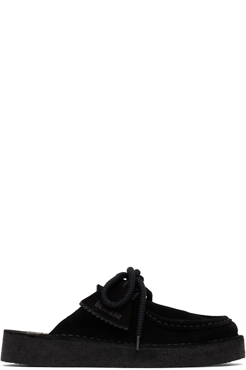 Suede mules in black. 

· Square moc toe
�· Logo tags at lace-up closure
· Bellows tongue
· Logo stamp at molded footbed
· Grained leather lining
· Crêpe rubber sole

Supplier color: Black suede