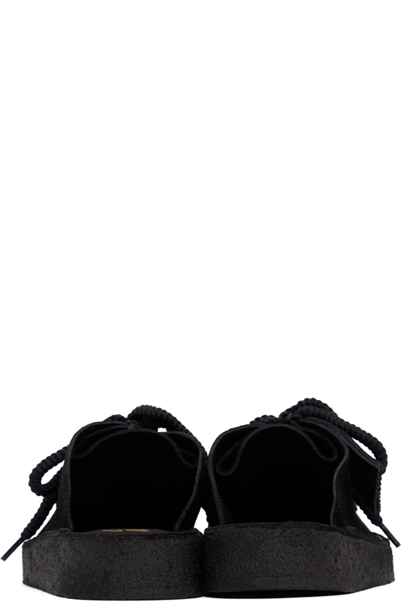 Suede mules in black. 

· Square moc toe
· Logo tags at lace-up closure
· Bellows tongue
· Logo stamp at molded footbed
· Grained leather lining
· Crêpe rubber sole

Supplier color: Black suede